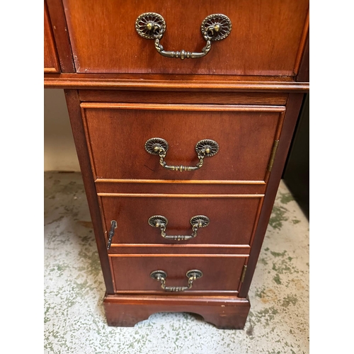 104 - A green leather topped pedestal desk, a long central drawer flanked by four short drawers and a cupb... 