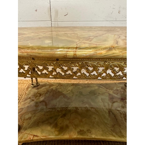 122 - A green marble topped oval coffee table in the Regency style with brass cherub supports (H45cm W115c... 