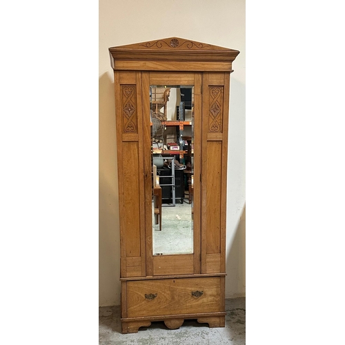 151 - A vintage pine Arts and Crafts style wardrobe with single mirrored door opening to cross rail hangin... 