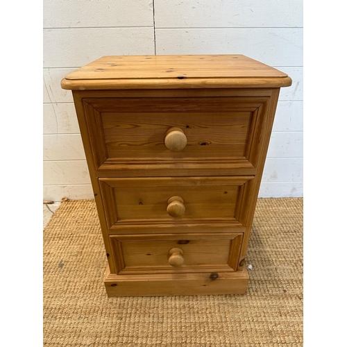 21 - A pine three drawer bedside table (H65cm W45cm D38cm)