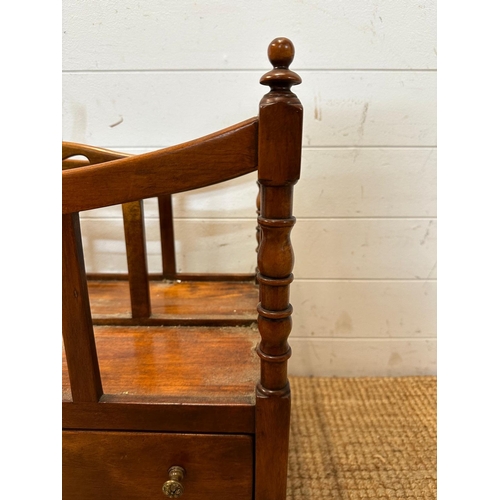 26 - A mahogany single drawer canterbury on turned supports and castors with turned finials to top