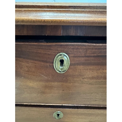 27 - A mahogany George III style chest of drawers comprising of three long drawers with brass back plate ... 