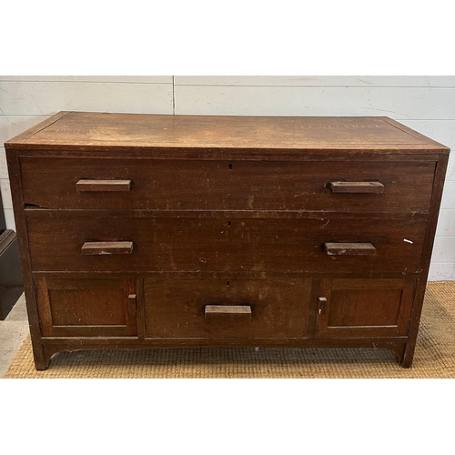 32 - An oak sideboard with two long drawers over one central drawer that is flanked by two cupboards AF (... 