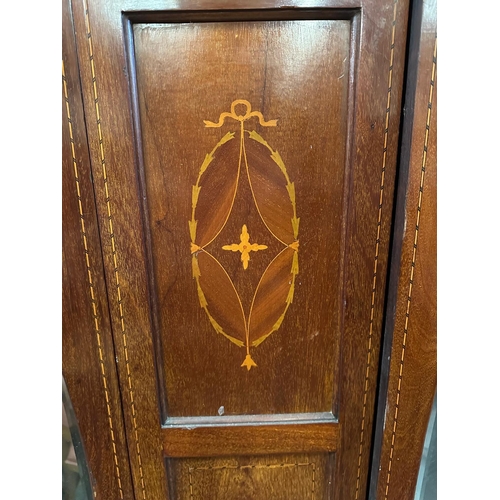 35 - A mahogany and inlaid wardrobe comprising of two mirrored doors flanking an ornate central shield wi... 