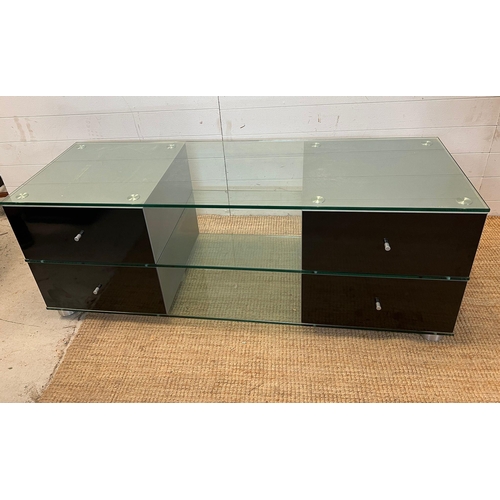 39 - A glass media unit with drawers to ends (H54cm W150cm D53cm)