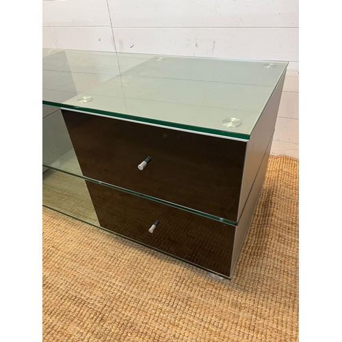 39 - A glass media unit with drawers to ends (H54cm W150cm D53cm)