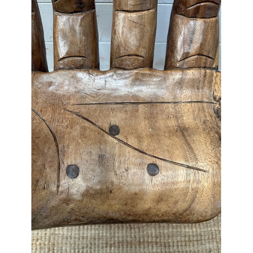 49 - A wooden carved seat or stool in the form of hand (H62cm)