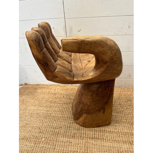 49 - A wooden carved seat or stool in the form of hand (H62cm)