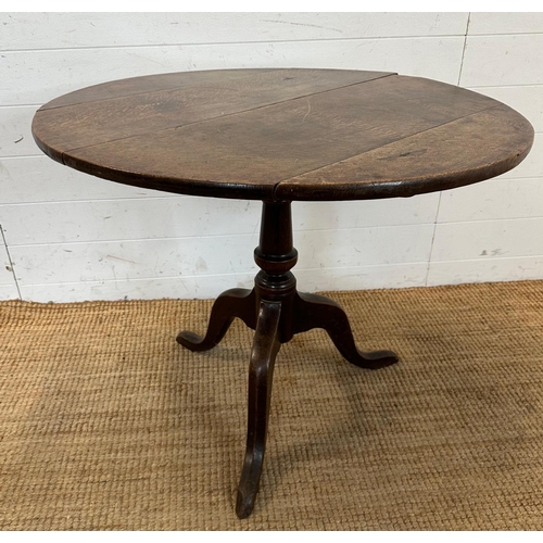 55 - A circular oak pedestal table. Turned central support on splayed tripod legs. Diameter 83 height 70