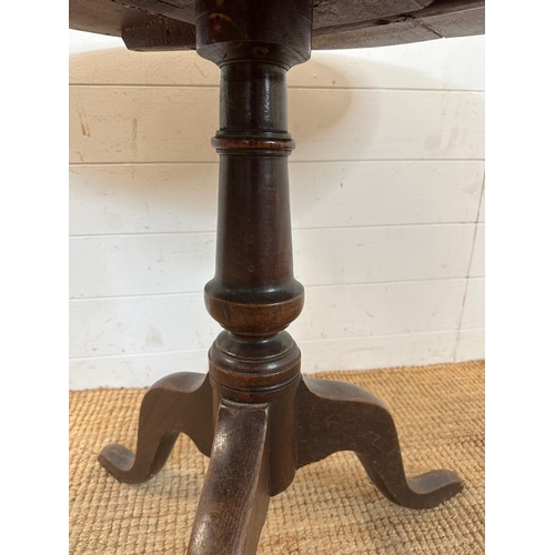 55 - A circular oak pedestal table. Turned central support on splayed tripod legs. Diameter 83 height 70