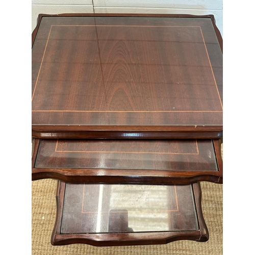 56 - A nest of three glass top side tables with string inlay on fluted legs