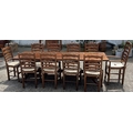 A large oak dining table with ten ladder back chairs (H73cm W243cm D90cm)