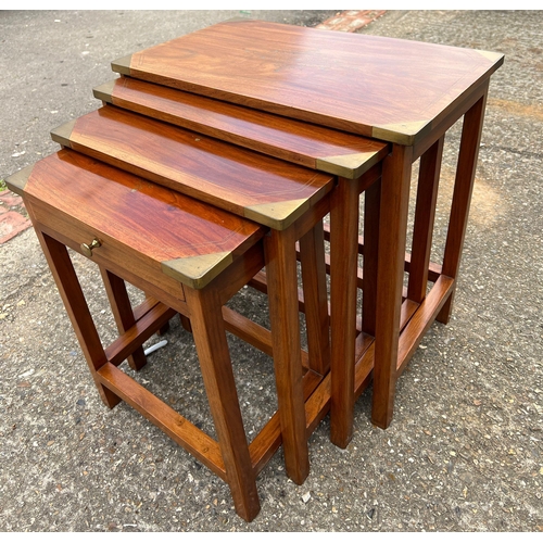68 - A nest of four tables with brass cap corners