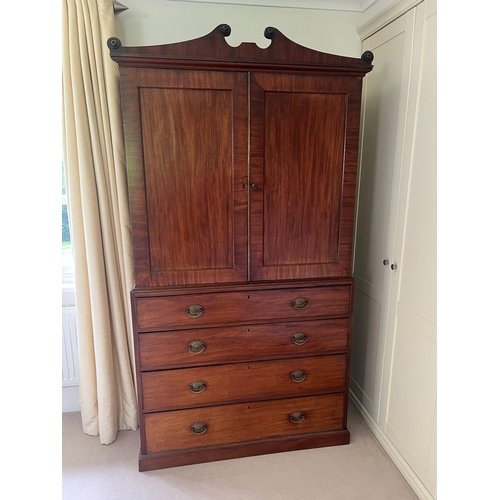 71 - A Regency mahogany linen cupboard with panelled doors opening to fixed shelves sat upon a base compr... 