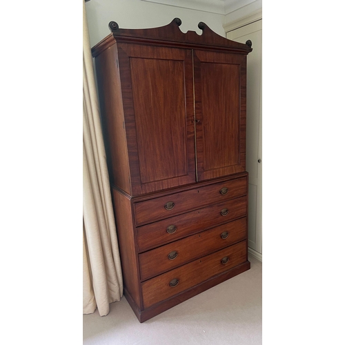 71 - A Regency mahogany linen cupboard with panelled doors opening to fixed shelves sat upon a base compr... 