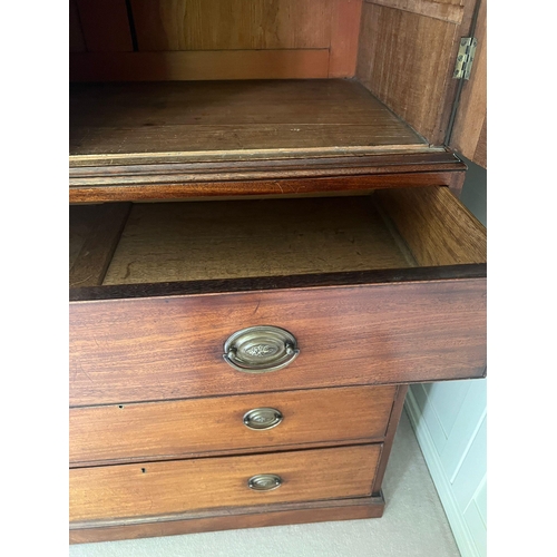 71 - A Regency mahogany linen cupboard with panelled doors opening to fixed shelves sat upon a base compr... 