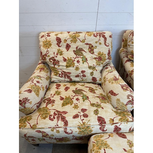 87 - A three seater sofa with matching arm chair and footstool by Edward Ferrell upholstered in a scrolli... 