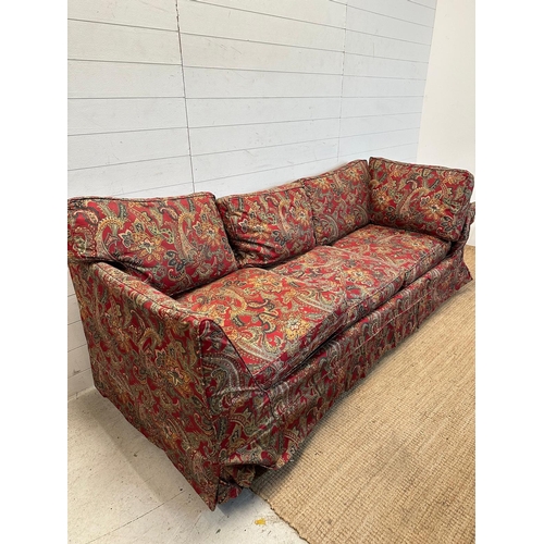 90 - A red paisley upholstered corner sofa