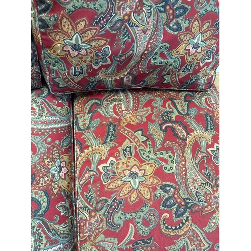 90 - A red paisley upholstered corner sofa