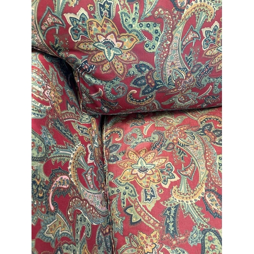 90 - A red paisley upholstered corner sofa