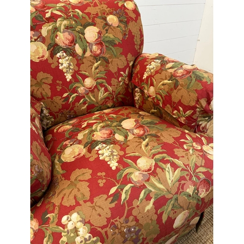 91 - A pair of swivel arm chairs upholstered in a red ground fruit tree fabric