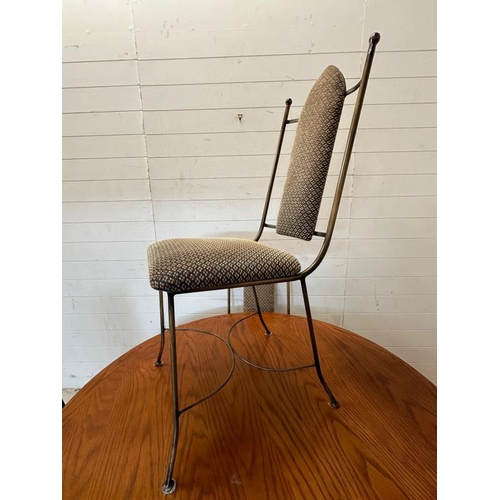 22 - A wrought iron circular dining table and chairs, the table with a wooden top and the chairs upholste... 