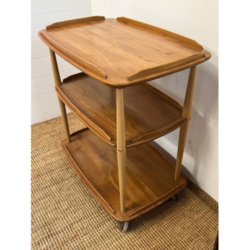 23 - An Ercol Windsor light elm three tier trolly with lipped edges (76cm x 66cm x 42cm)