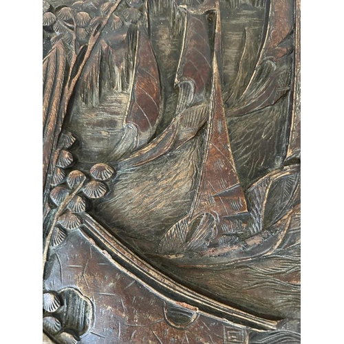 29 - A Chinese ornately carved camphor wood chest with brass fittings and featuring a desert scape scene ... 