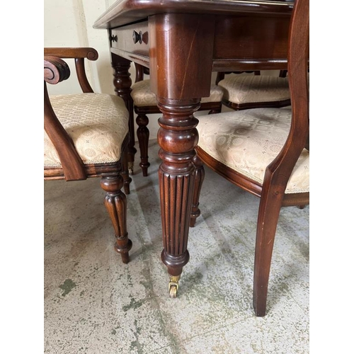 38 - A mahogany extendable dining table on turned and reeded legs ending in castors with six chairs and t... 