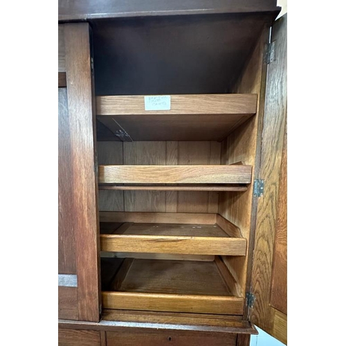 5 - An Arts and Crafts style oak linen press, the cupboard opening to four drawers over two short and tw... 