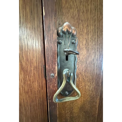5 - An Arts and Crafts style oak linen press, the cupboard opening to four drawers over two short and tw... 