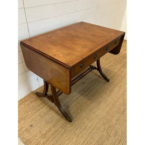 53 - A drop sided sofa table with twin stretcher and out splayed legs (H74cm W94cm D61cm)