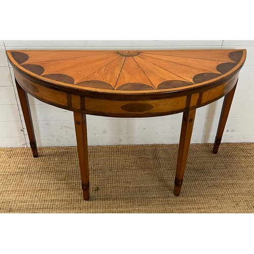 55 - A Demi Lune side table with veneered top on tapering legs (H73cm W130cm D47cm)