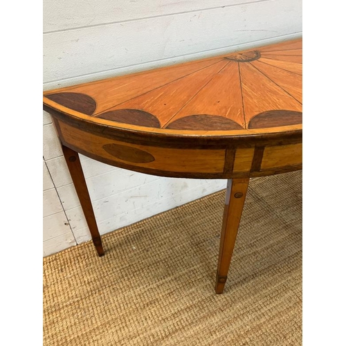55 - A Demi Lune side table with veneered top on tapering legs (H73cm W130cm D47cm)