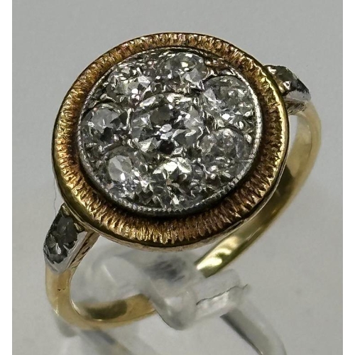 580 - A diamond ring with central stone surrounded by seven others with diamond shoulders Size L