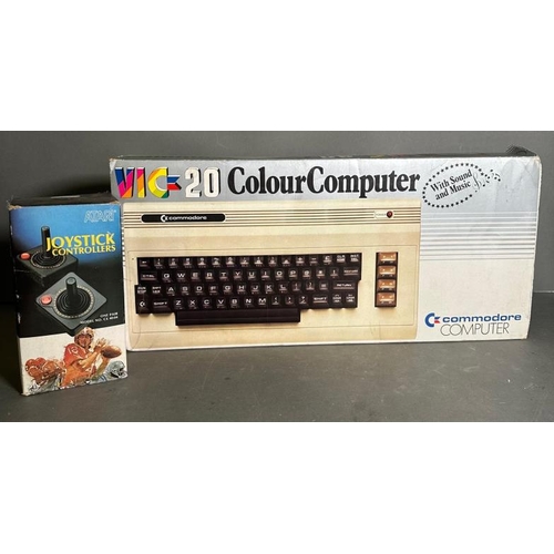 809 - A boxed Commodore Vig 20 colour computer and a pair of Atari joystick controllers