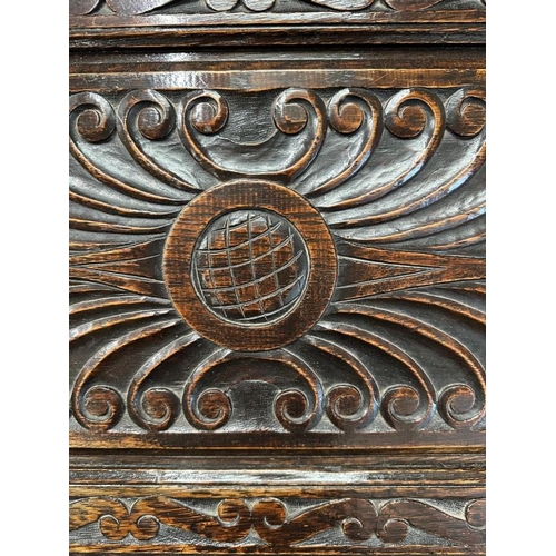 87 - A dark oak ornately carved book case bureau, the green glazed cupboard opening to central cupboard f... 