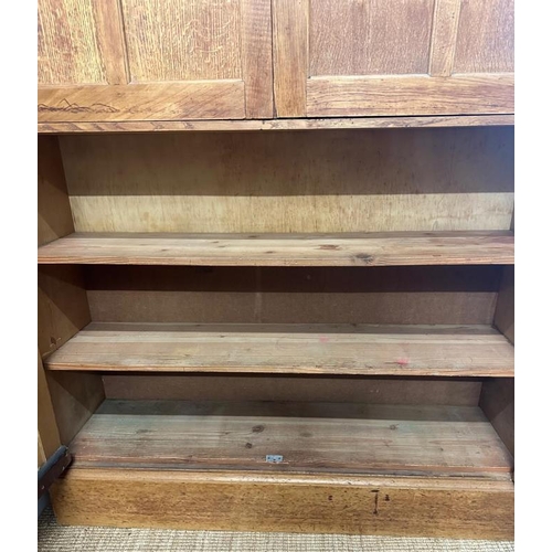 9 - A large arts and crafts pine kitchen storage cupboard, two over two door cupboards with a total of f... 