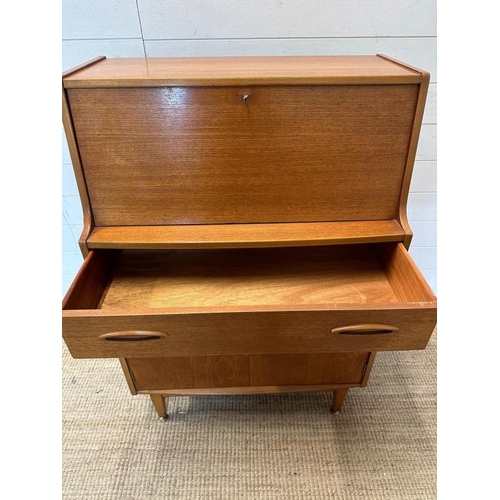 14 - A teak Mid Century bureau, single long drawer with cupboard under. The fall opening to two small dra... 