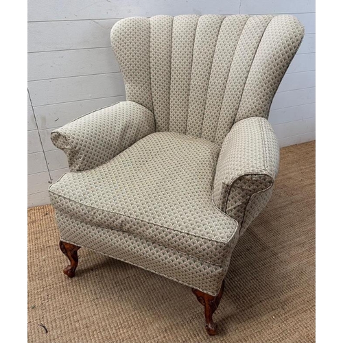 1 - A wingback arm chair upholstered in green on carved front legs