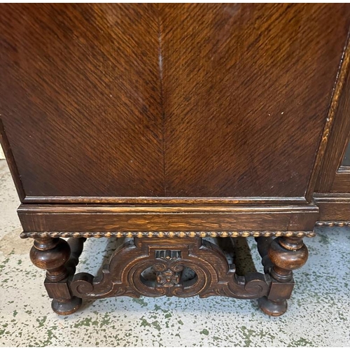 108 - An oak carved sideboard with central glazed doors flanked by two cupboards (H110cm W152cm D45cm)