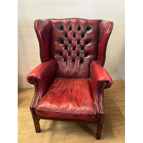 121 - A red leather chesterfield wing back chair