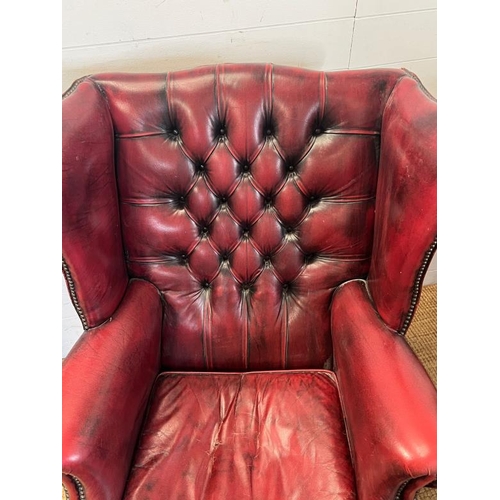 121 - A red leather chesterfield wing back chair