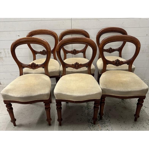 105 - A set of six balloon back chairs on turned front legs in a beige upholstery
