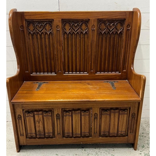 83 - A Gothic style monks bench with hinged lid and linen fold detail (H103cm W94cm D41cm)