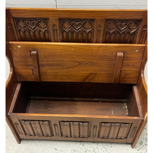 83 - A Gothic style monks bench with hinged lid and linen fold detail (H103cm W94cm D41cm)