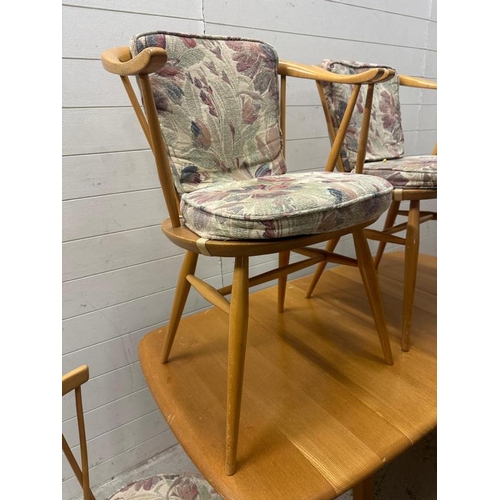182 - A mid century drop leaf dining table with four spindle back chairs and two carvers