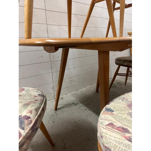 182 - A mid century drop leaf dining table with four spindle back chairs and two carvers