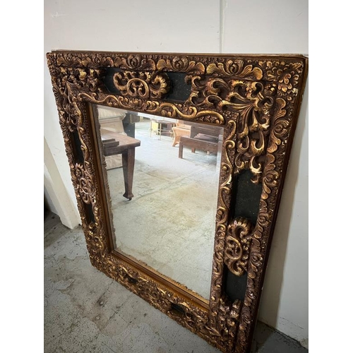 202 - A large scrolling embossed mirror. H149 X 124 X D65cm