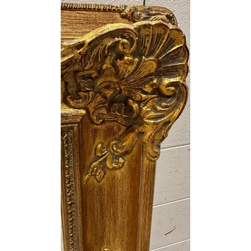 204 - A wooden gold painted mirror in the baroque style 79cm x 94cm